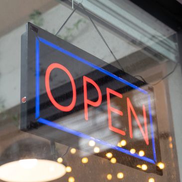 Neon sign displaying the word 'OPEN' in red and blue colors.