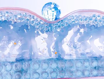Close-up of a water droplet on a surface with blue bubbles inside.