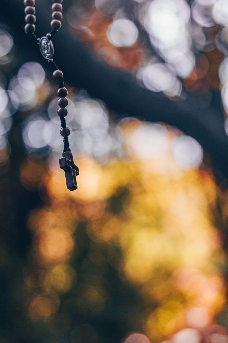 Wooden rosary with cross - with bokeh in background