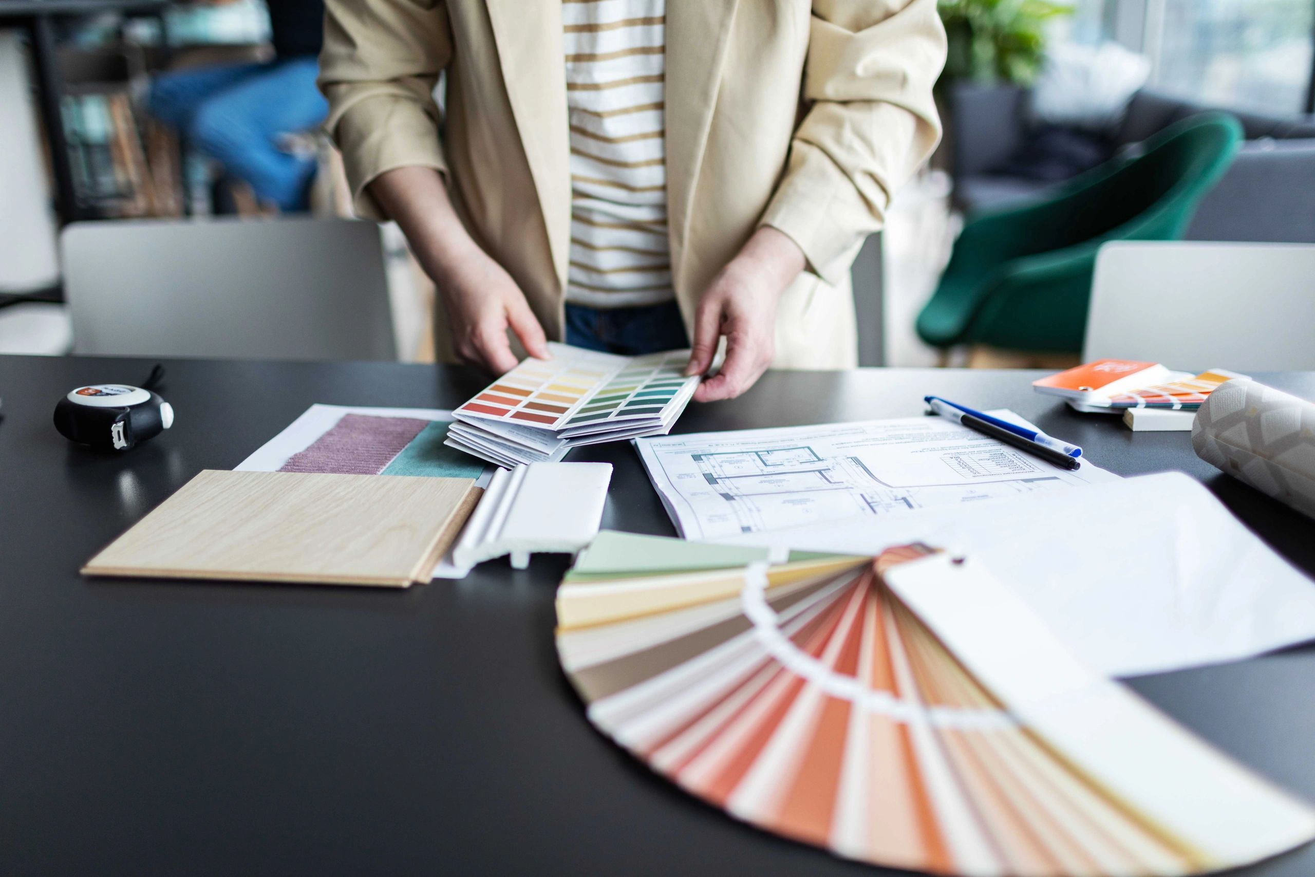 Person selecting colors from a palette at a desk.