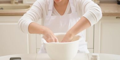 Person mixing dough in a bowl.
