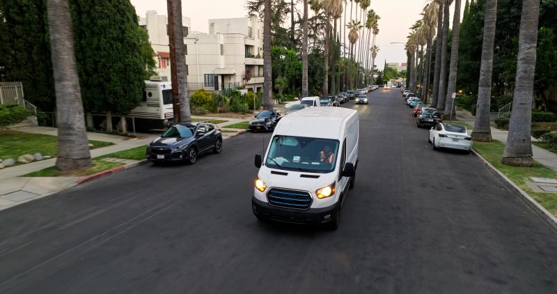 Aerial shot of a white delivery van on a residential street in Los Angeles, California in the evening.