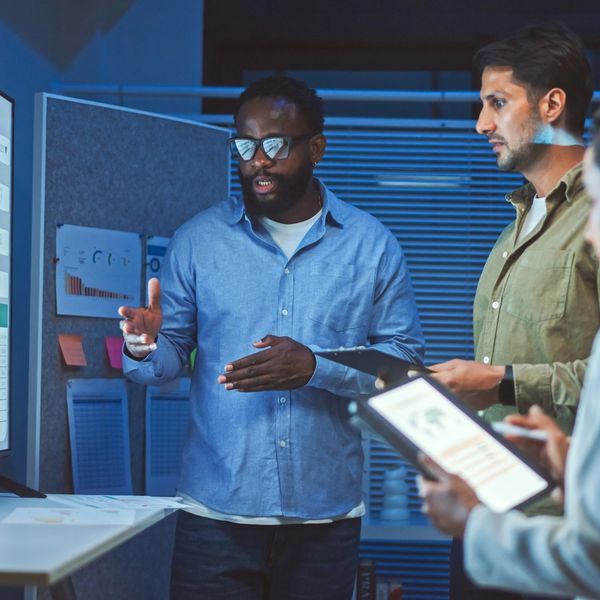 A team analyzes data on a large screen during a meeting.