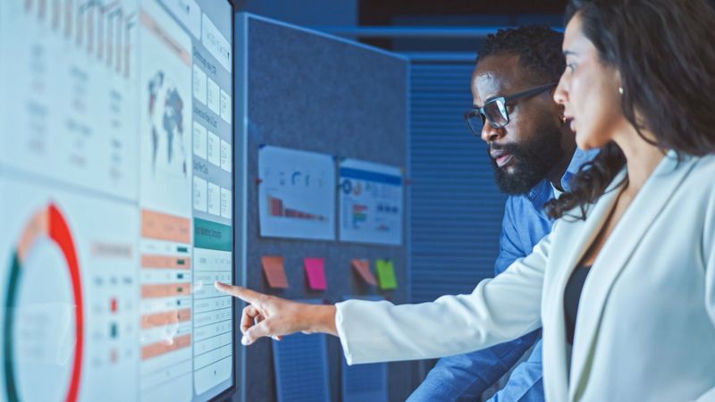 A team of multiethnic developers is meeting to review the data analysis of marketing from social media platforms.