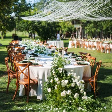 Elegant outdoor wedding reception with floral decorations.
