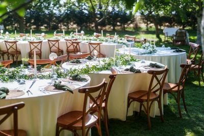 Outdoor event with elegant round tables and chairs.