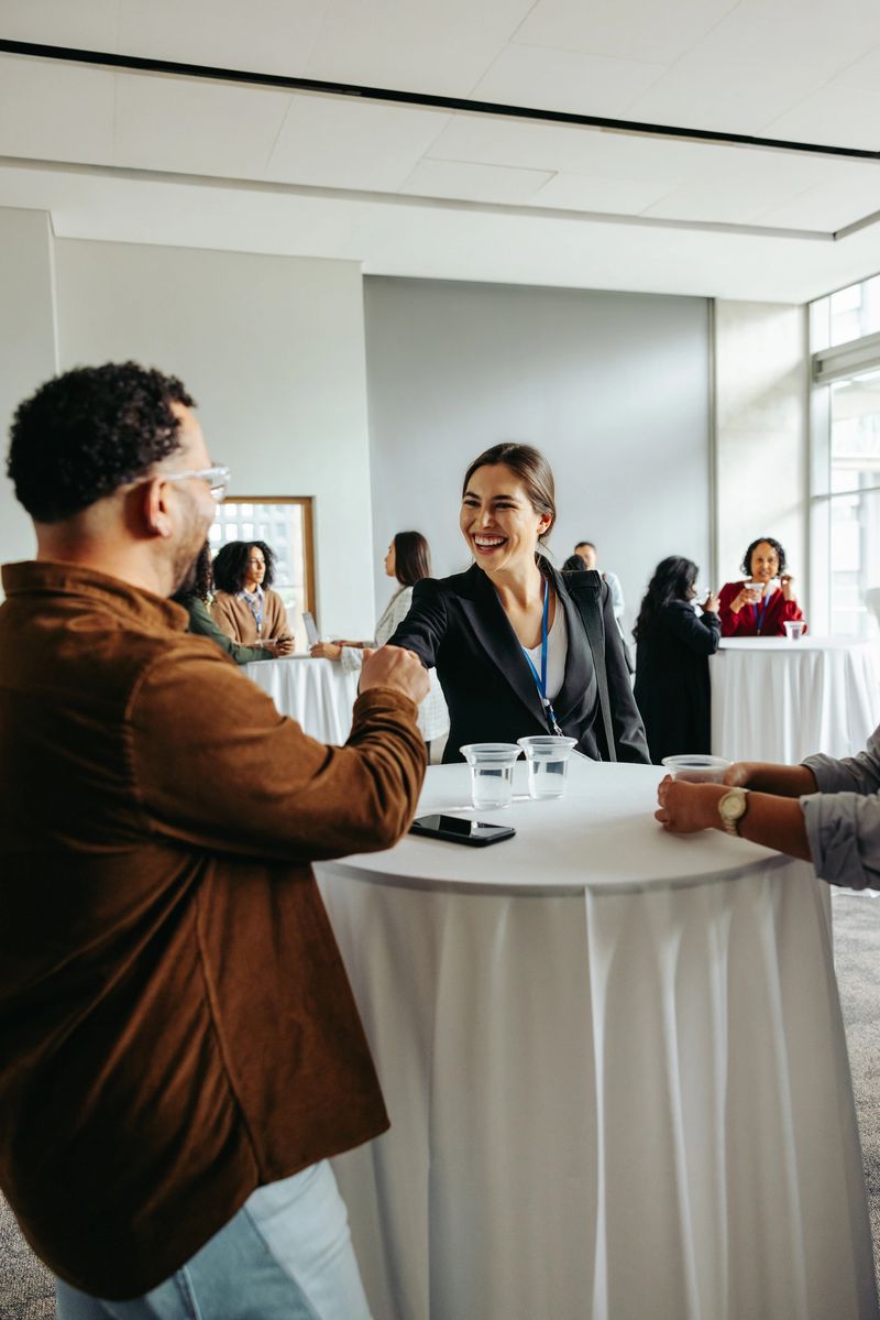 Corporate professionals mingle and enjoy refreshments at a networking event, fostering connections and friendly interactions.