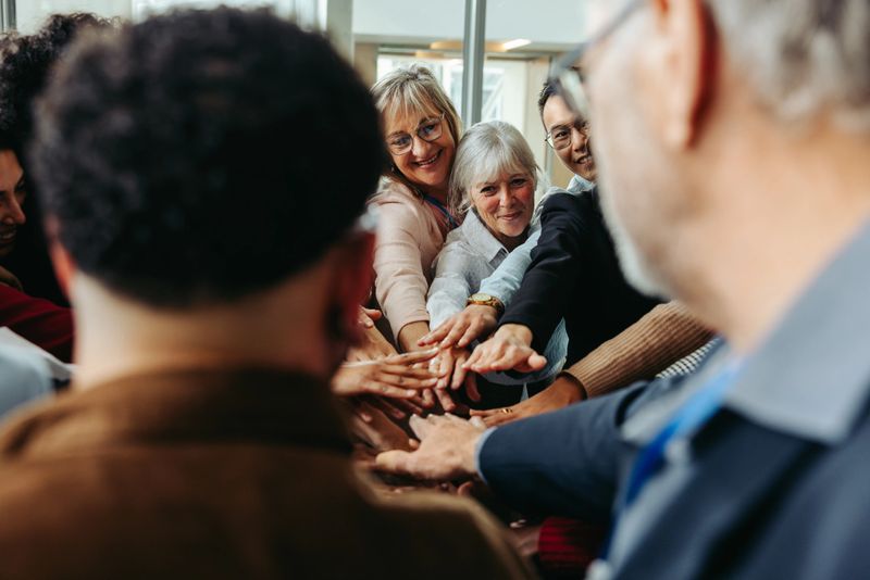 Mature women and colleagues in a business huddle demonstrating teamwork, collaboration, and unity in a professional environment.
