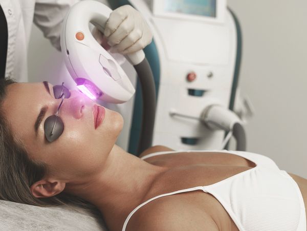 Woman undergoing a laser skin treatment with eye protection.