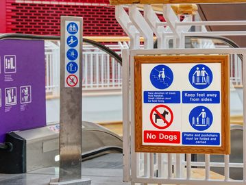 Safety and no dogs signs at a subway entrance.