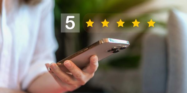 Person holding a smartphone with a five-star rating overlay. emergency technician and plumber 
