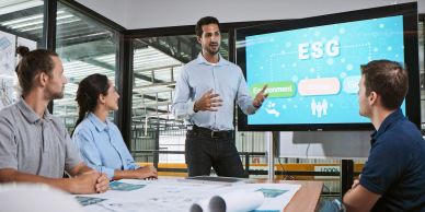 Man presenting ESG concepts to colleagues in a meeting.