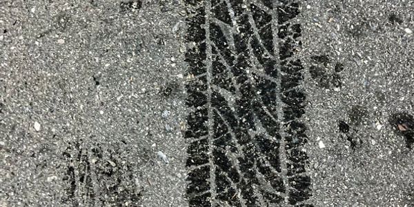 Close-up of tire tracks on asphalt.