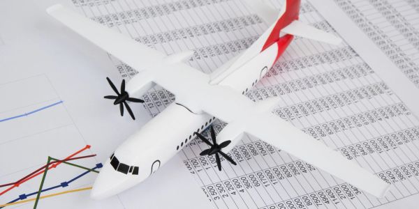 Model airplane on financial charts and data sheets.