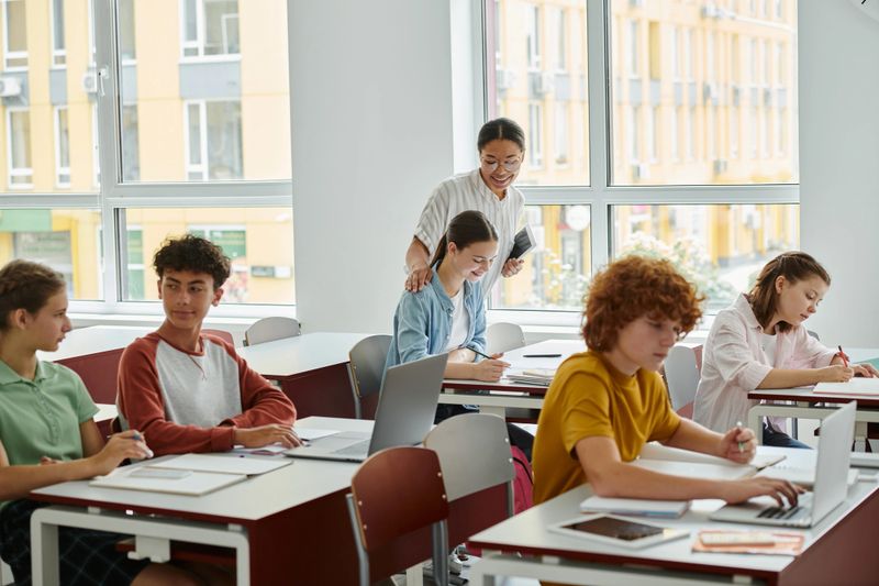 Students actively participate in group work during a productive back-to-school day near teacher