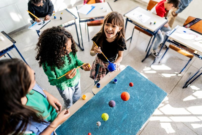Students doing solar system project on classroom at school