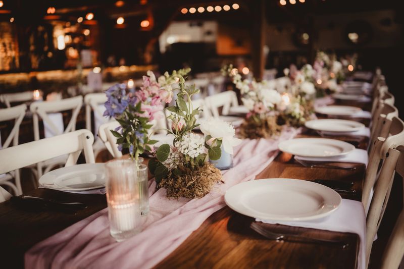 Centerpieces at a wedding with flowers, candles and ribbon