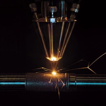 Close-up of metal welding sparks in a dark setting.
