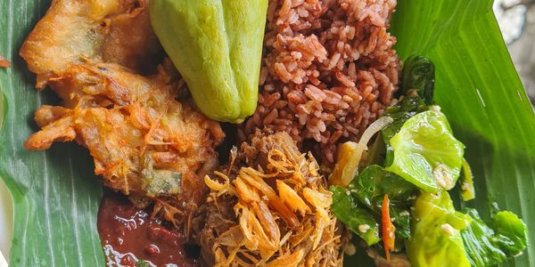 Traditional meal served on a banana leaf with rice, vegetables, and fried items.
