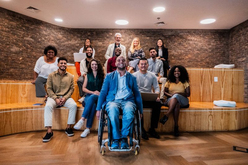 Portrait of a wheelchair businessman and coworkers during presentation at office