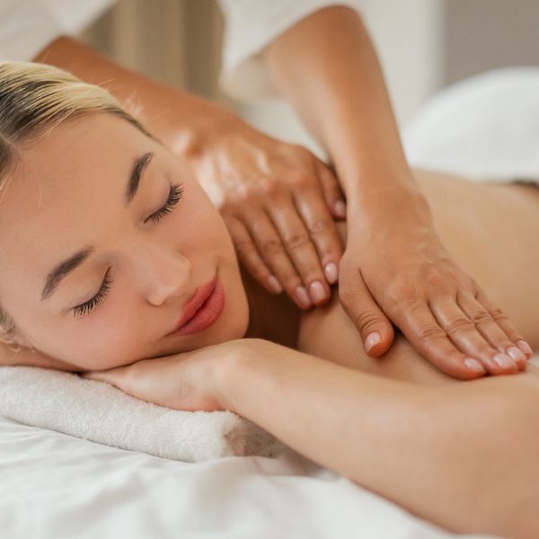 Woman enjoying a relaxing back massage with eyes closed.
