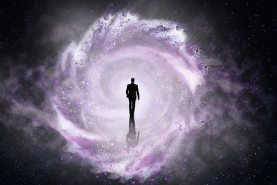 A man walking into a swirling cosmic vortex in space.