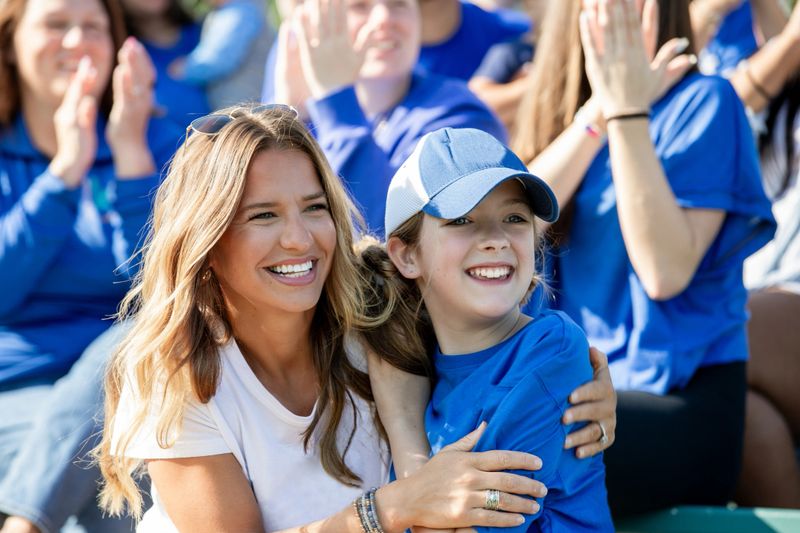 Mom and daughter hug while cheering on their favorite college football team