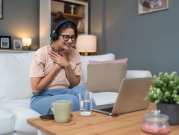 person in front of laptop with headphones on 