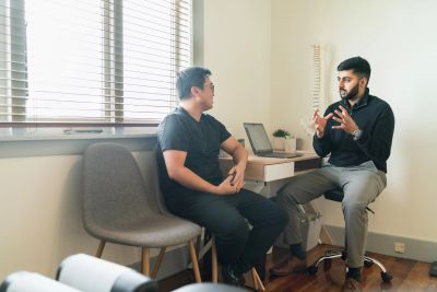 Two men having a serious discussion in a bright office room.