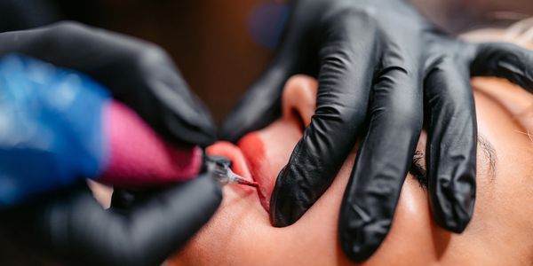 Close-up of a lip tattoo procedure.