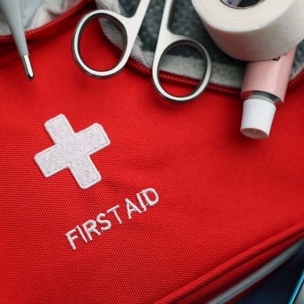Red first aid kit with medical tools.