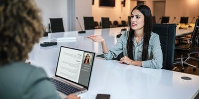 A woman is being interviewed in a modern conference room.