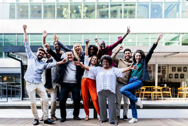 Portrait of coworkers celebrating outdoors