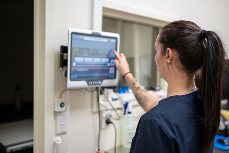 A young female nurse operating a touch screen in a medical clinic