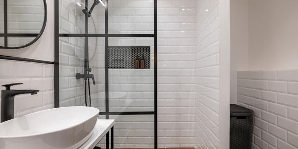 Modern bathroom with black fixtures and white subway tiles.