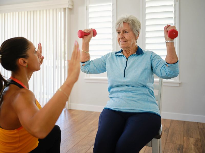 Senior woman following a custom in-home exercise program guided by a personal trainer