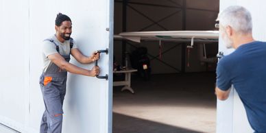 Two men opening large hangar doors with aircraft inside.
