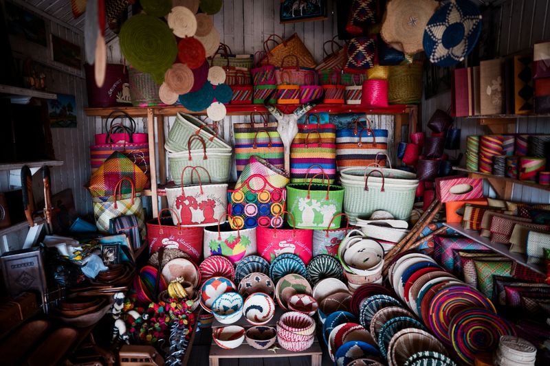 Vibrant handmade souvenirs fill the shelves of a market in Madagascar, featuring intricately designed baskets and crafts made from local materials.