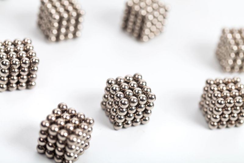 cubic composed with magenetic balls random arranged on white background