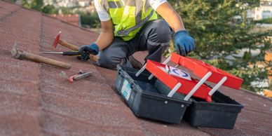 Worker fixing a roof with tools.