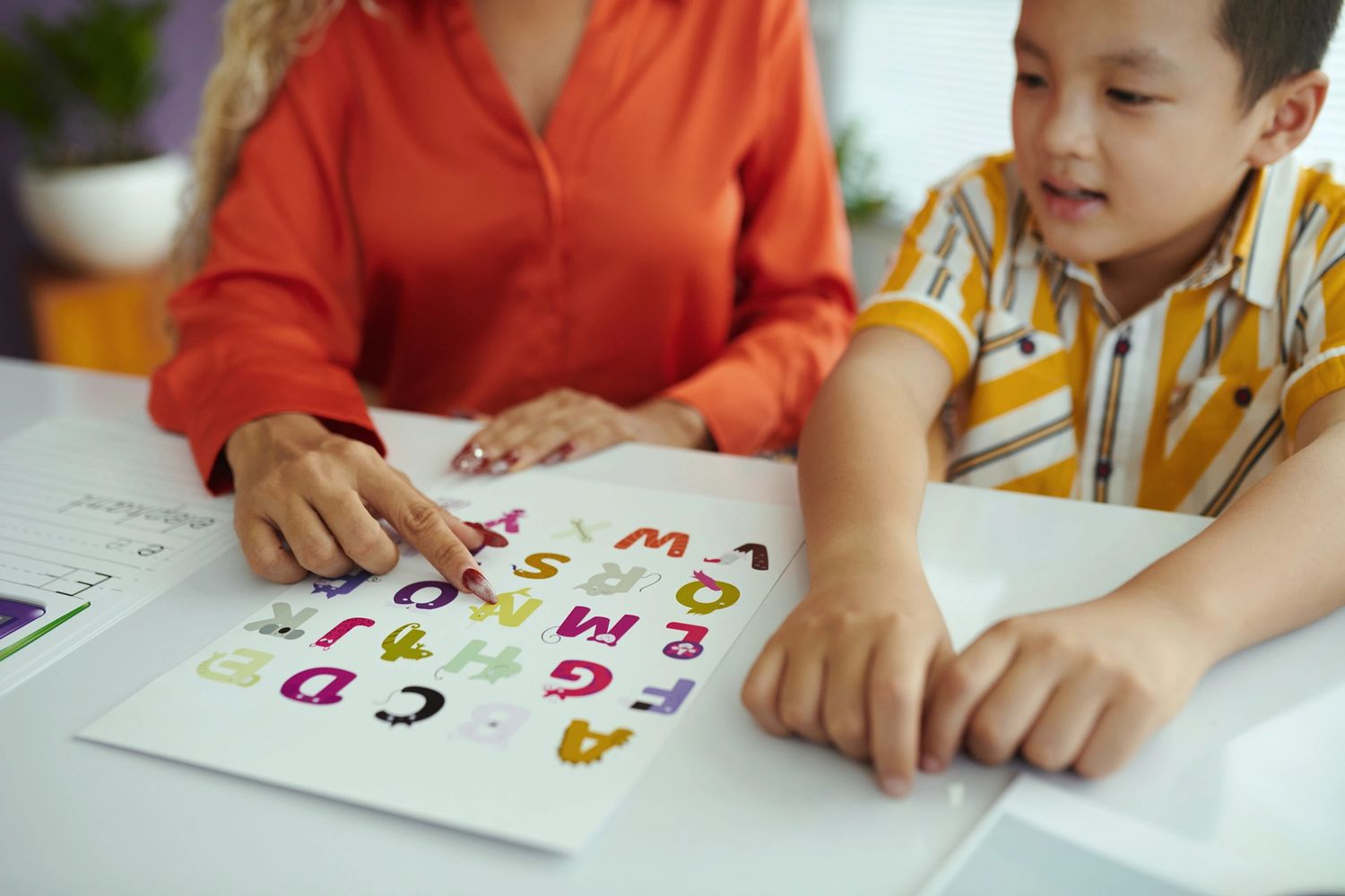 Stack of books next to pencils in a holder and a camera.