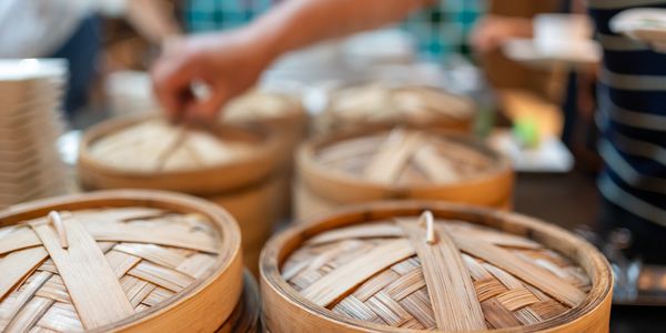 Dim sum and tea set on a wooden table in a restaurant.