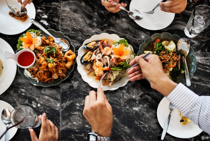 Top view of people sharing Thai food at a restaurant