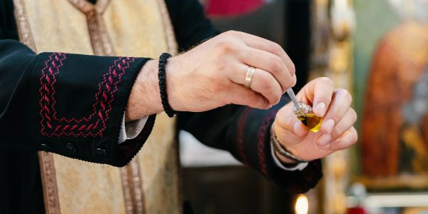 Person holding a dropper with oil.