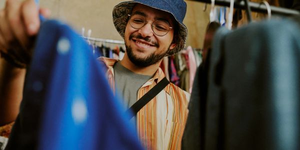 Man happily shopping for clothes in a store.