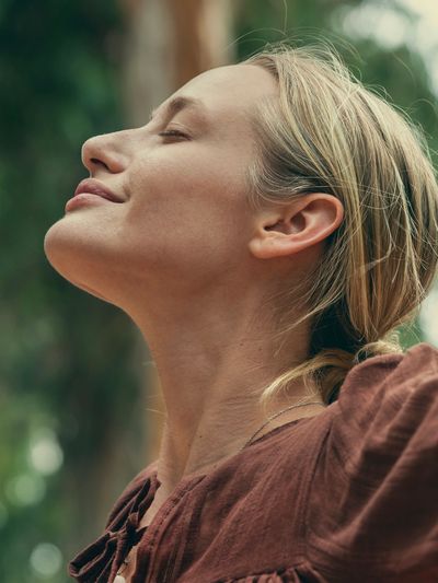 Woman with closed eyes enjoying a peaceful moment outdoors.
