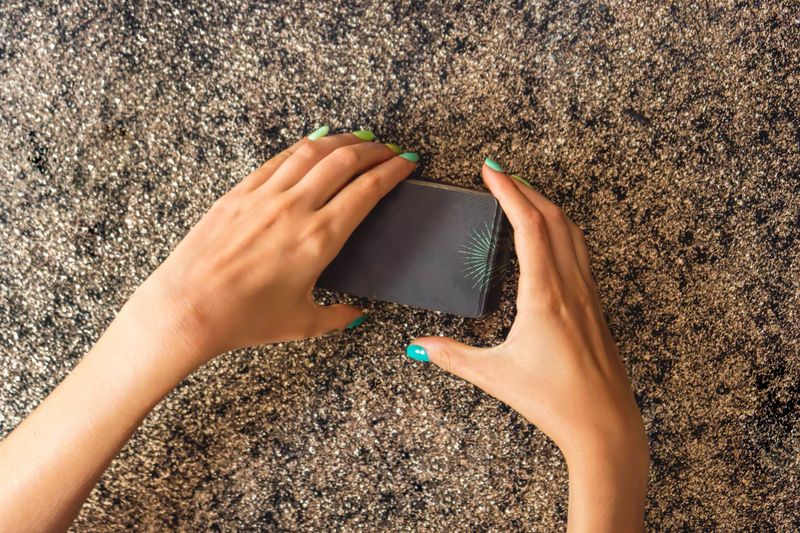 Top view of a client's hands cutting a tarot deck