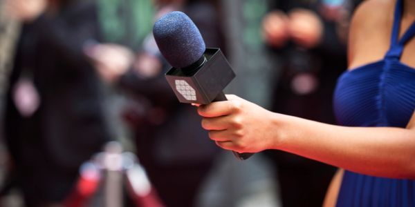 Microphone tenu dans une main lors d'une interview.