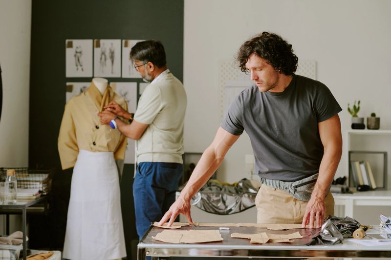Biracial atelier workers working on new female collection together in modern atelier