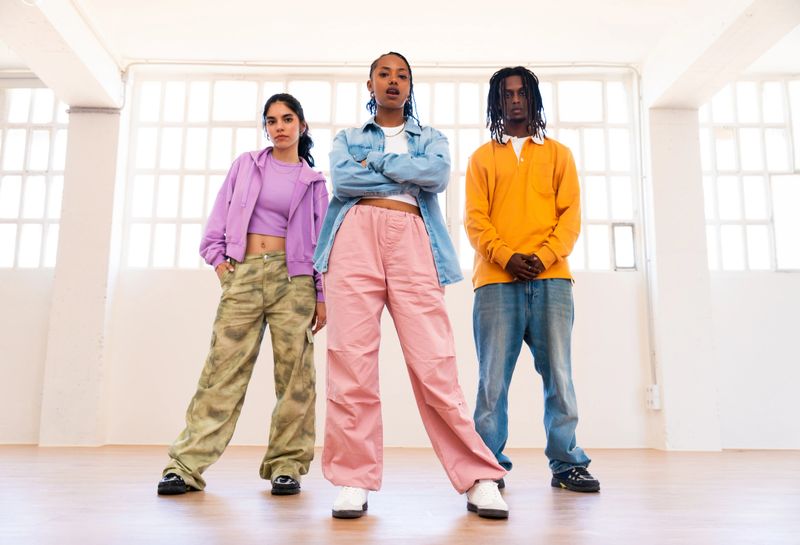 Young group of multiethnic hip-hop dancers wearing colorful urban streetwear dancing - Stylish multiracial rap crew portrait in indoors dancing studio